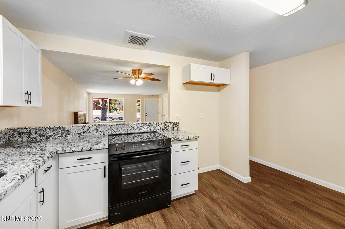 3670 Meeks Way Reno, NV 89503 - Photo 7 of 21 a kitchen with granite countertop a refrigerator and a stove