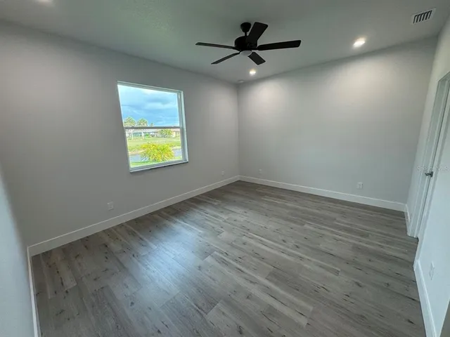 an empty room with a window and a ceiling fan