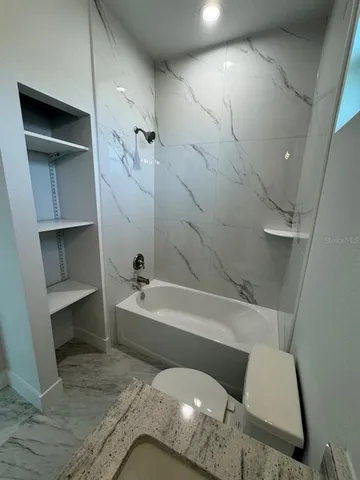 a bathroom with a tub and toilet