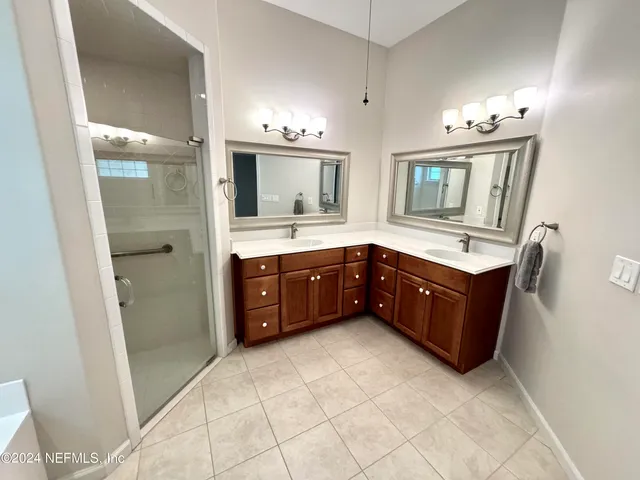 a spacious bathroom with a vanity a sink a mirror and a bathtub