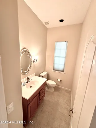 a bathroom with a toilet sink and mirror