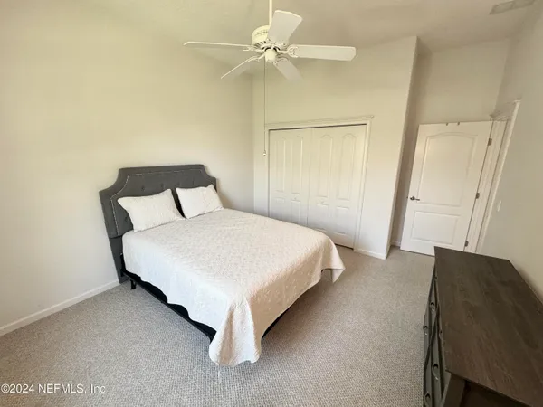 a bedroom with a bed and a ceiling fan