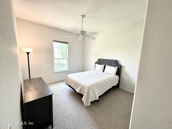 a bedroom with a bed and a night stand