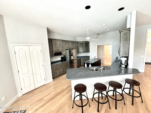 a kitchen with granite countertop white cabinets and stainless steel appliances