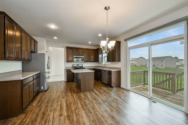 a large kitchen with lots of counter space a sink and stainless steel appliances