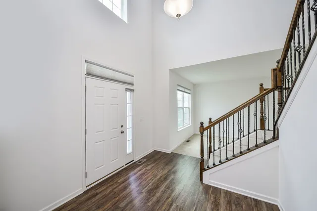 a view of a hallway with wooden floor and staircase
