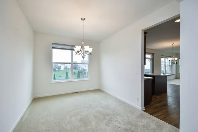 a view of a room window wooden floor and chandelier