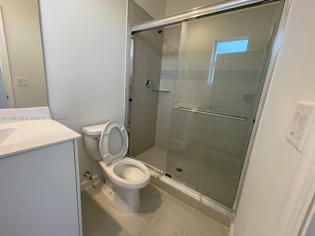 29111 Southwest 162th Court Homestead, FL 33033 - Photo 11 of 15 a bathroom with a granite countertop toilet and a shower