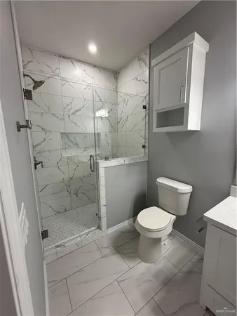 a bathroom with a toilet and a shower