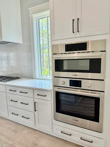 a view of a kitchen with granite countertop a sink and dishwasher a refrigerator with wooden floor