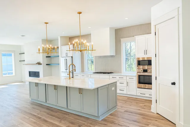 a kitchen with kitchen island granite countertop a stove and a wooden floors