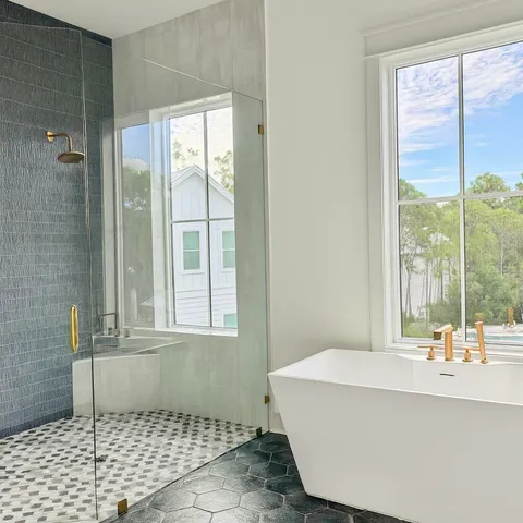 a bathroom with a granite countertop sink mirror and a bathtub
