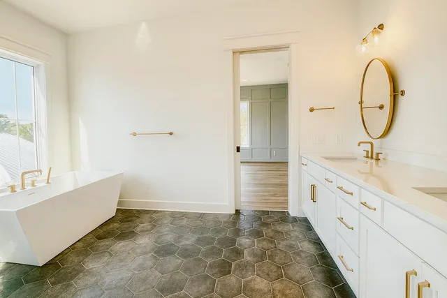 a bathroom with a tub sink and mirror