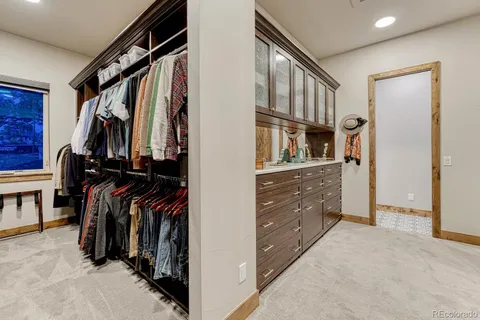 a view of walk in closet with clothes and shoes