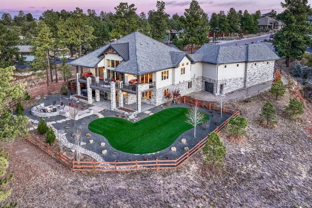 a view of a big house with a big yard potted plants and large trees