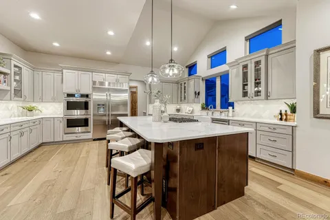 a kitchen with stainless steel appliances kitchen island granite countertop a sink and cabinets
