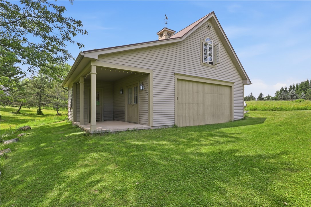 2057 Stirnie Road Victor, NY 14564 - Photo 41 of 48 The detached barn structure offers versatility with multiple overhead garage doors, a covered side porch entrance, a dedicated second-story loft space, and full electricity, it serves as a workshop, vehicle gallery, or agricultural storage facility.