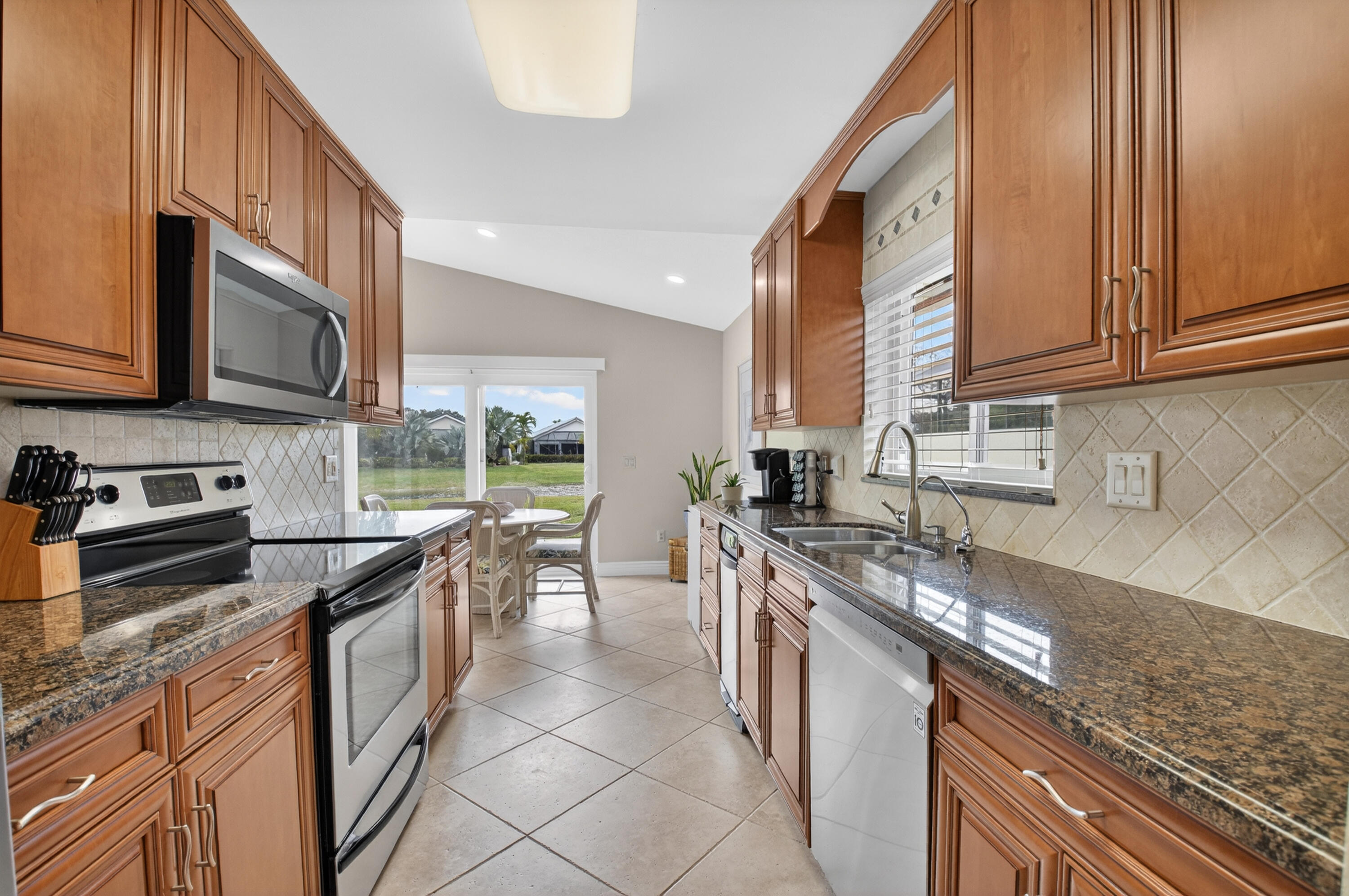 11253 Cloverleaf Circle Boca Raton, FL 33428 - Photo 22 of 79 a kitchen with stainless steel appliances granite countertop a stove a sink and a microwave