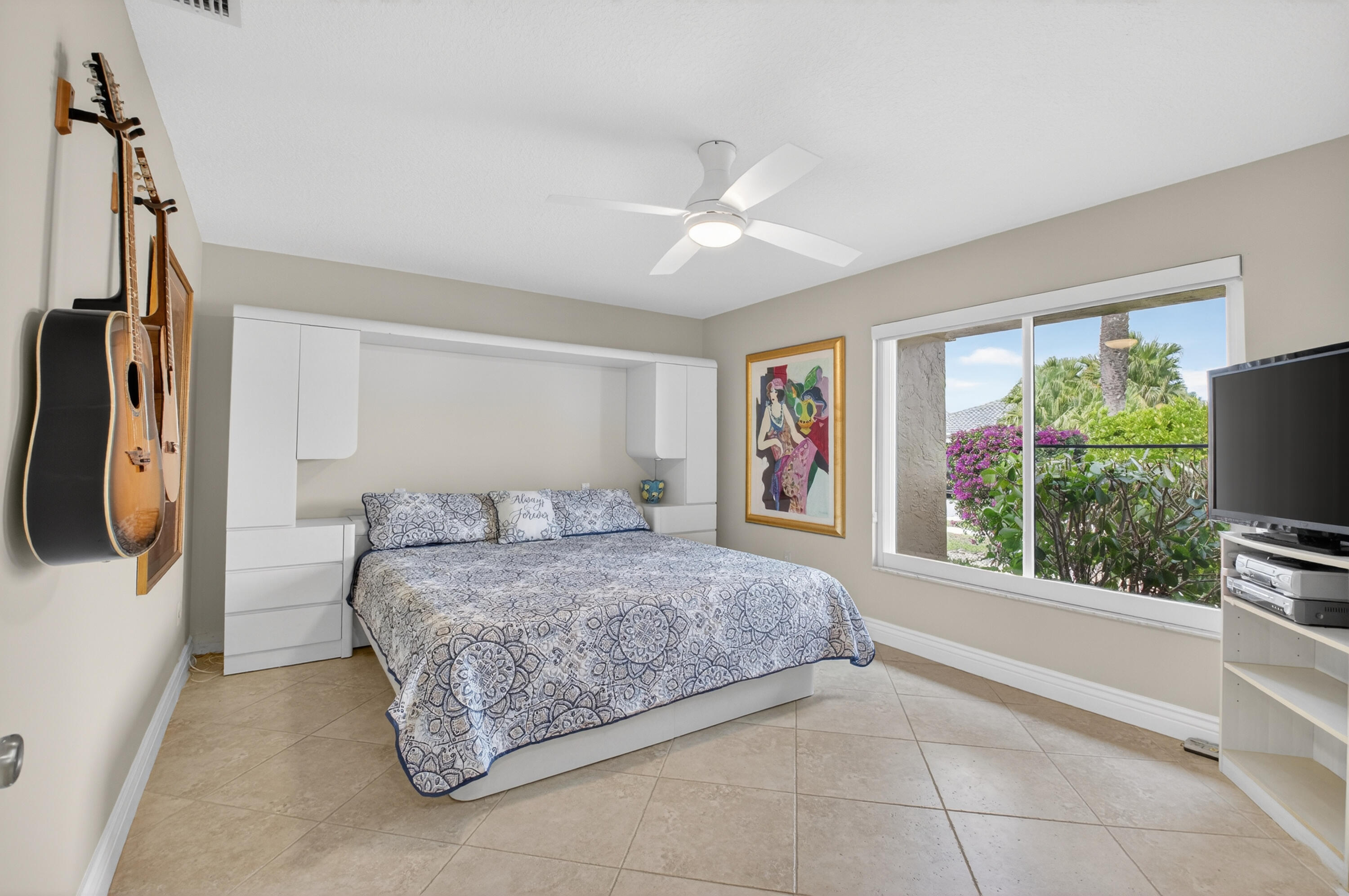 11253 Cloverleaf Circle Boca Raton, FL 33428 - Photo 32 of 79 a bedroom with a bed a couch and a flat tv screen on the dresser