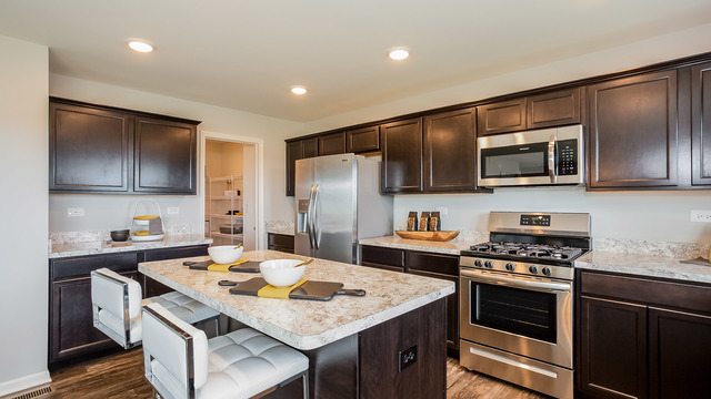 3738 Doherty Lane McHenry, IL 60050 - Photo 3 of 12 a kitchen with granite countertop stainless steel appliances and wooden cabinets