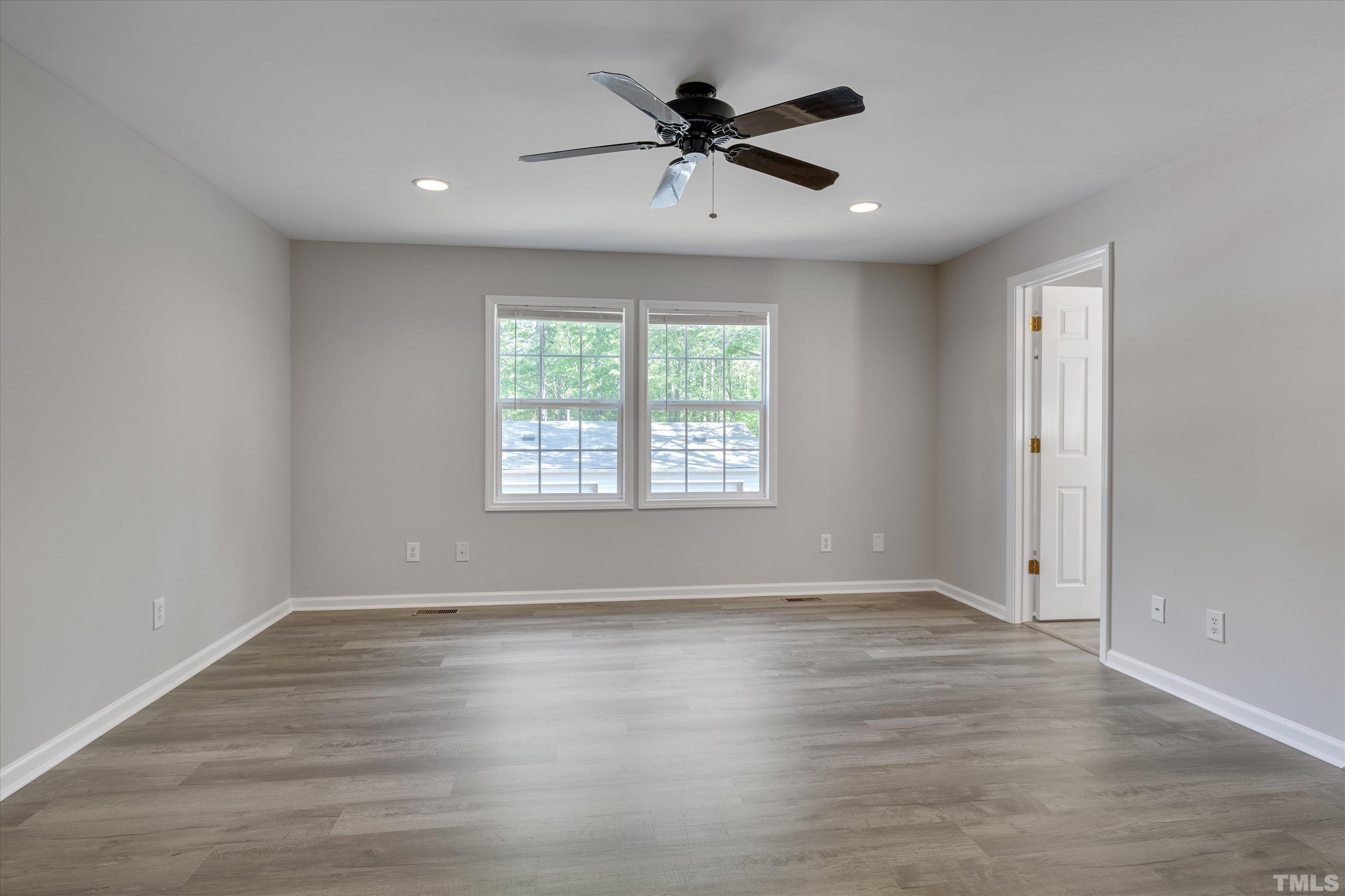 308 South Mineral Springs Road Durham, NC 27703 - Photo 16 of 42 an empty room with wooden floor and windows