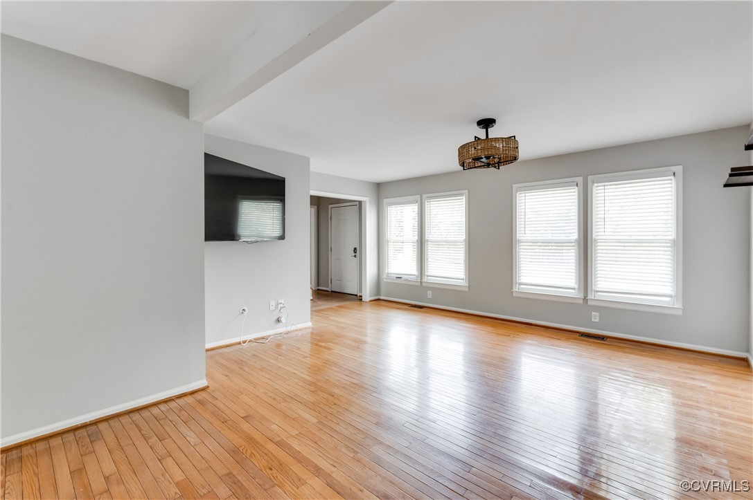 Empty room featuring baseboards, visible vents, an