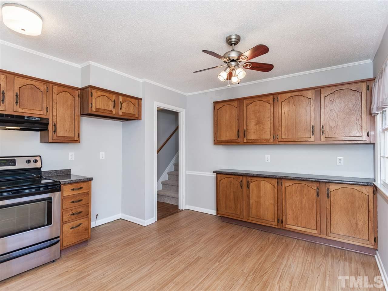 3000 Morningside Drive Raleigh, NC 27607 - Photo 4 of 25 a kitchen with stainless steel appliances granite countertop a refrigerator a sink dishwasher a stove and white countertops with wooden floor