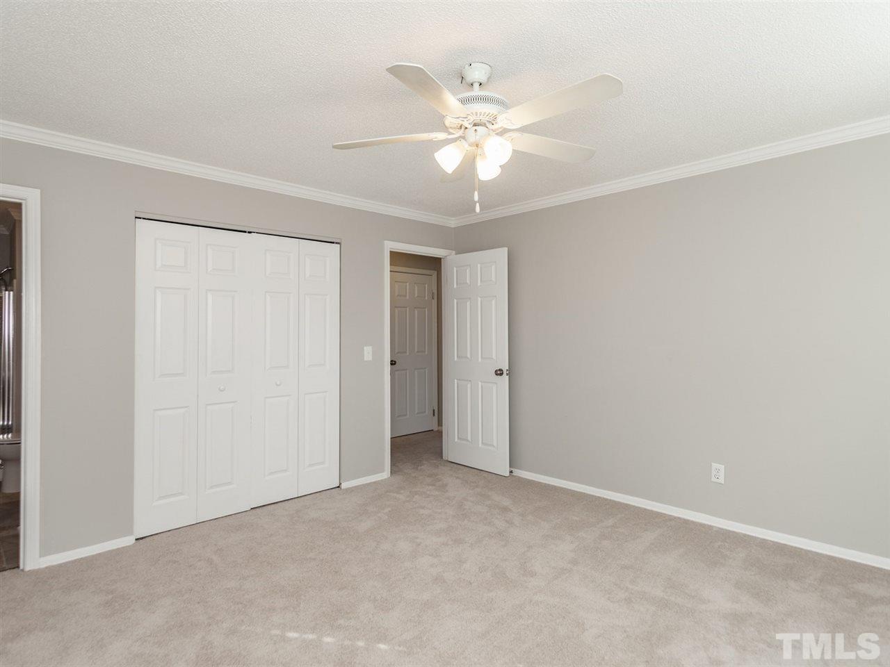 3000 Morningside Drive Raleigh, NC 27607 - Photo 9 of 25 an empty room with a chandelier fan and windows