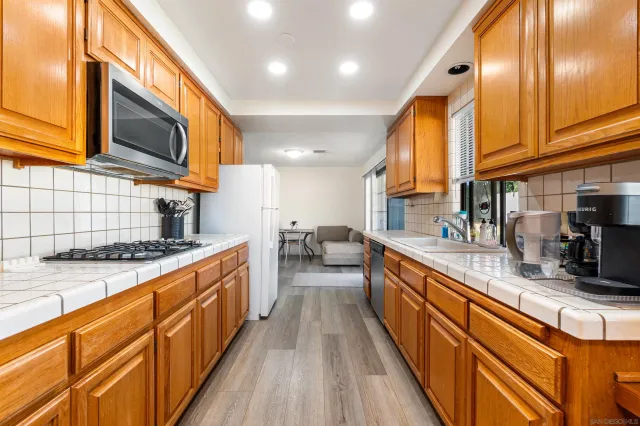 a kitchen with stainless steel appliances granite countertop a stove a sink and a microwave