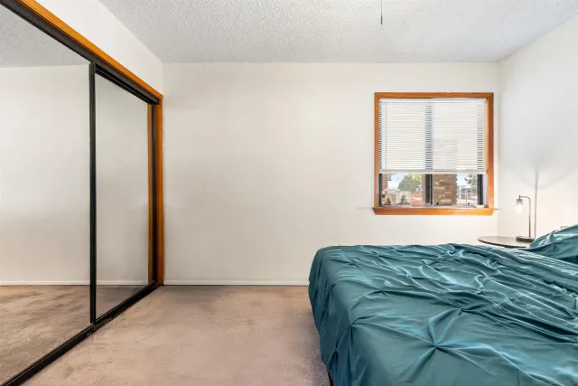 a bed sitting in a bedroom next to a window with dresser