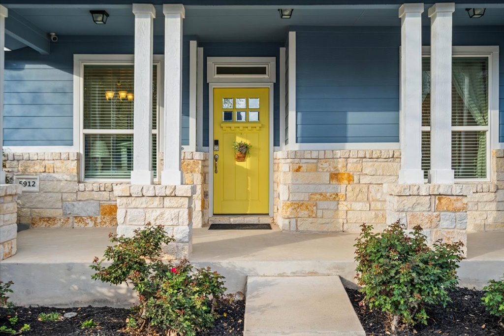 5912 Corrine Lane Austin, TX 78747 - Photo 2 of 27 Doorway to property with stone siding and a porch