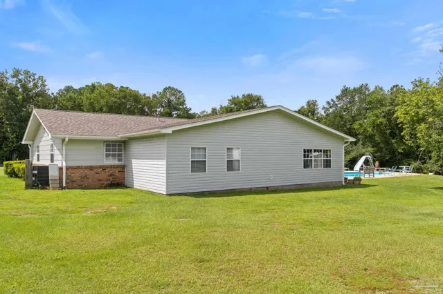 a view of a house with a big yard and a large tree