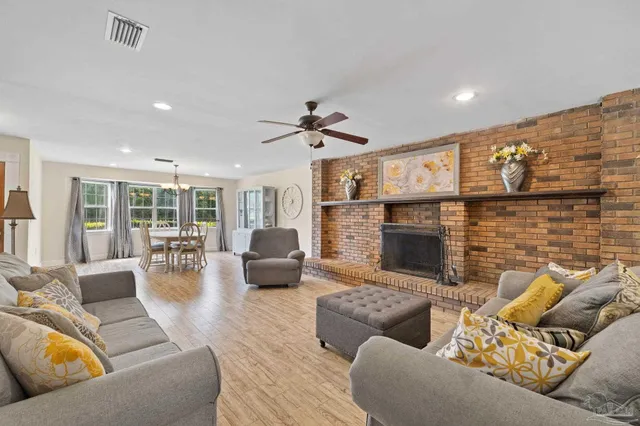 a dining room with furniture a chandelier and wooden floor