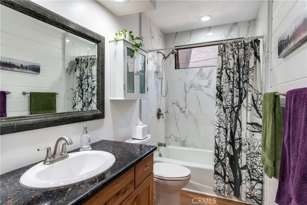 39444 Canyon Drive Forest Falls, CA 92339 - Photo 16 of 28 a bathroom with a granite countertop sink toilet a mirror a vanity and shower