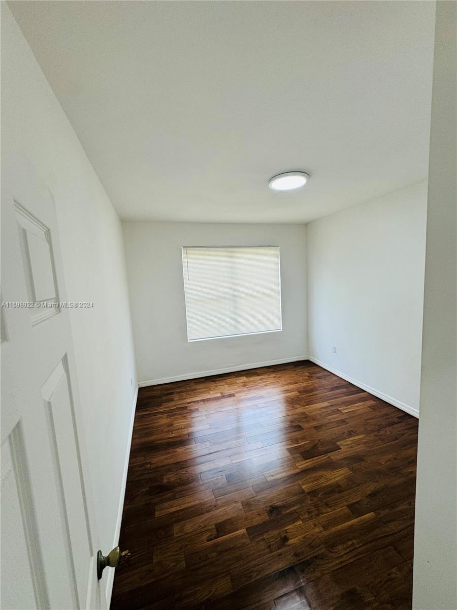 144 Northeast 43rd Street, Unit 2 Miami, FL 33137 - Photo 3 of 10 a view of an empty room with wooden floor and a window