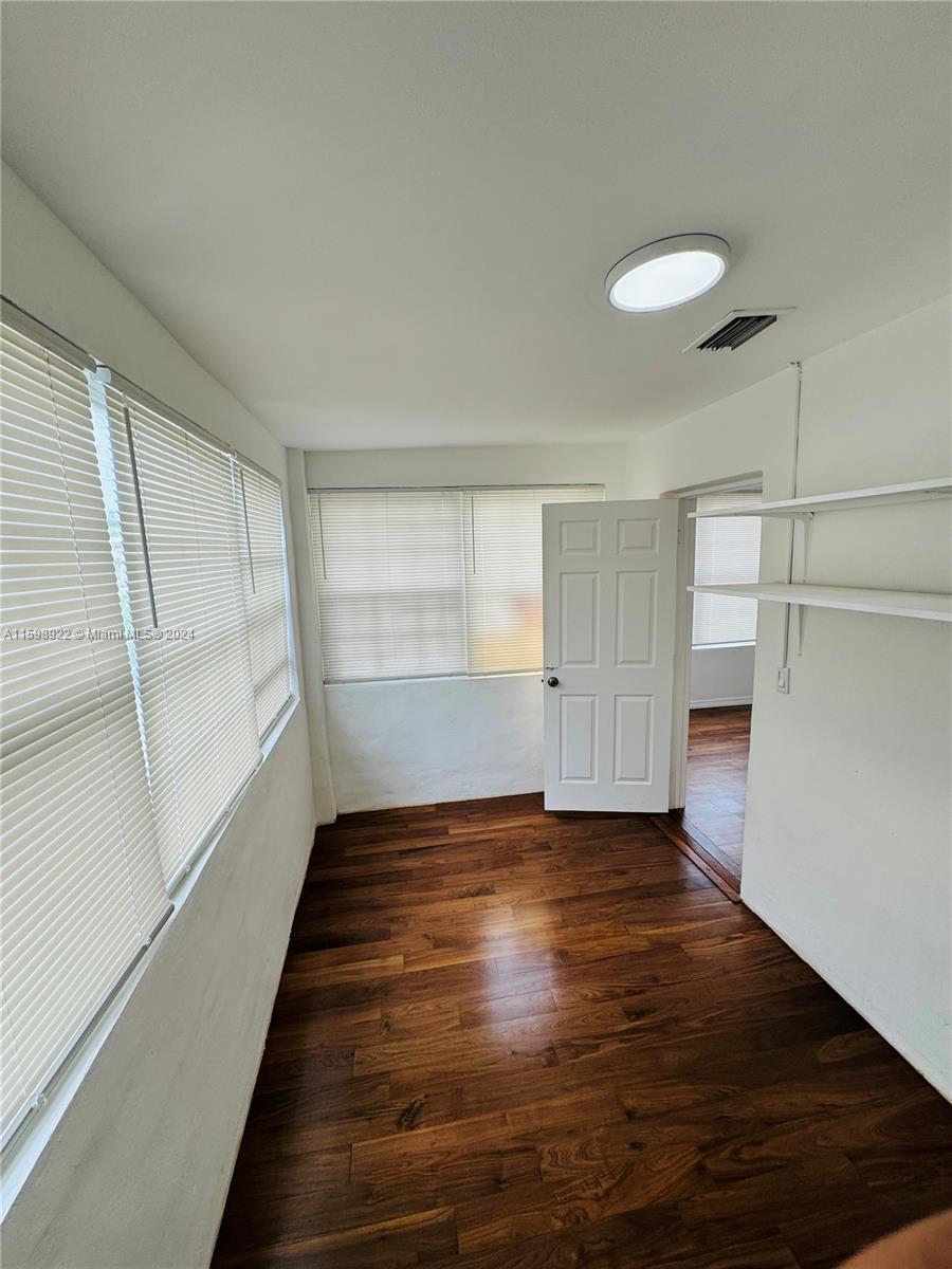 144 Northeast 43rd Street, Unit 2 Miami, FL 33137 - Photo 9 of 10 a view of an empty room with wooden floor and a window
