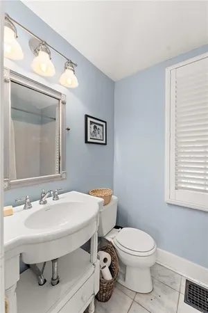 a bathroom with a toilet a sink and a window