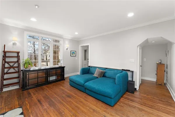 a living room with furniture and a wooden floor