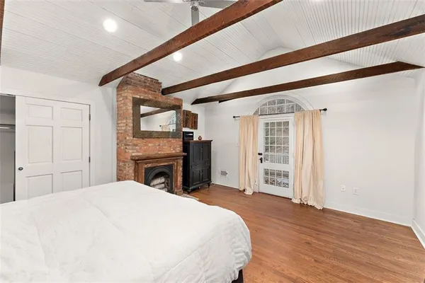 a bedroom with a large bed and a flat tv screen