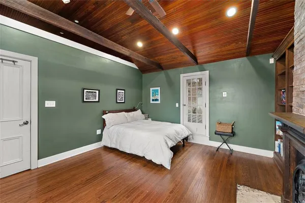 a spacious bedroom with a bed and a wooden floor