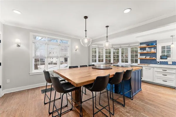 a dining room with furniture window and wooden floor