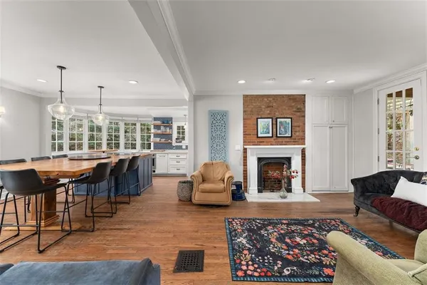 a living room with furniture a fireplace and a large window