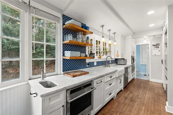 a kitchen with stainless steel appliances granite countertop a stove and a large window