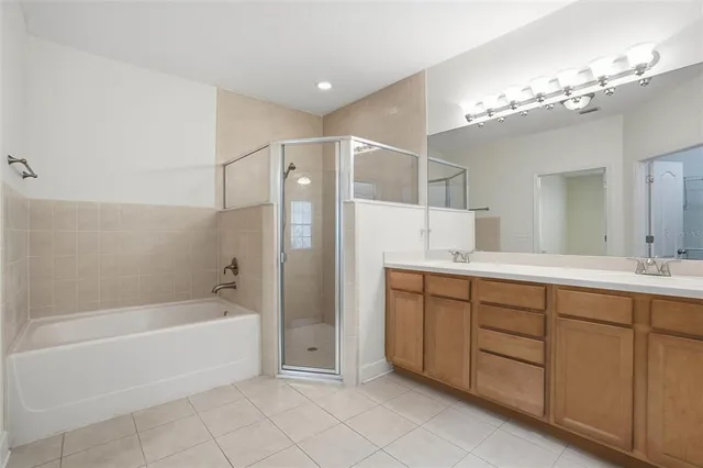 a spacious bathroom with a tub sink and mirror