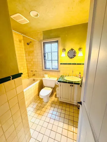 a bathroom with a sink mirror toilet shower and bathtub