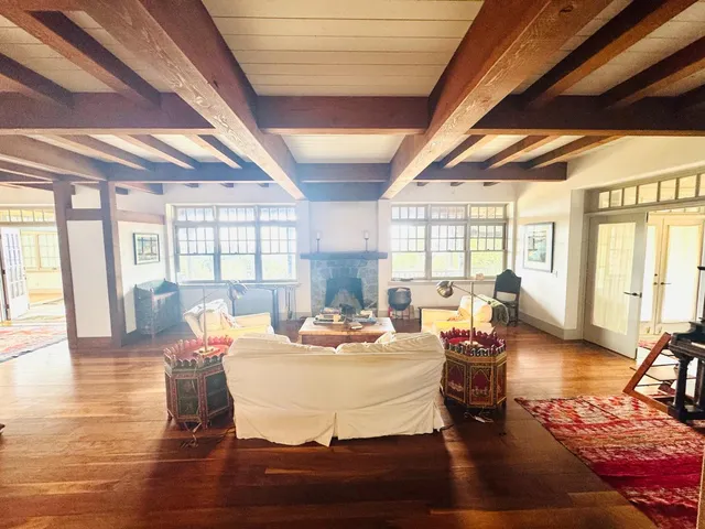 a living room with fireplace furniture and a large window