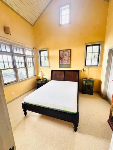 a bed sitting in a bedroom next to a window