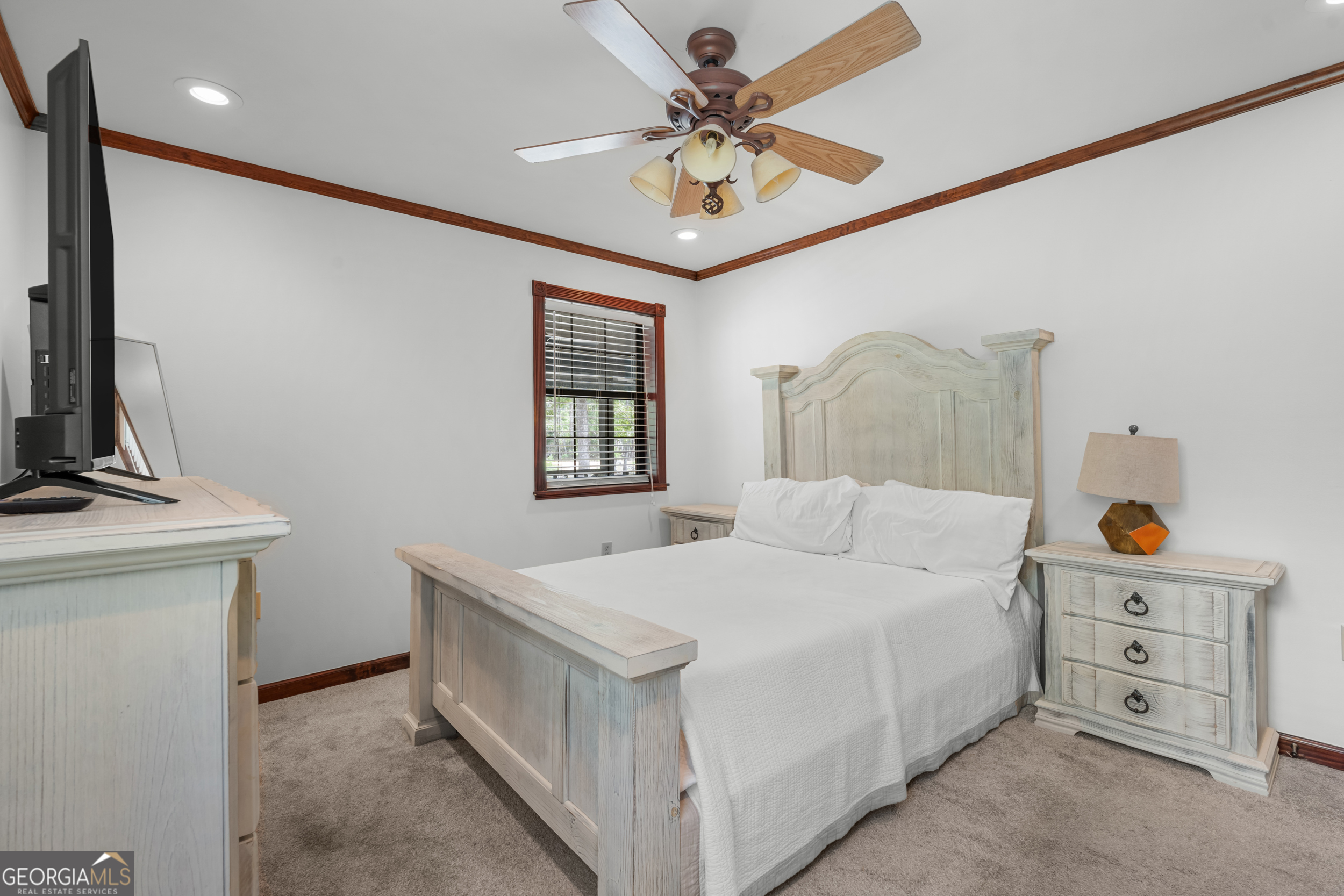 3770 Hill Road Metter, GA 30439 - Photo 17 of 32 a bedroom with a bed and a chandelier
