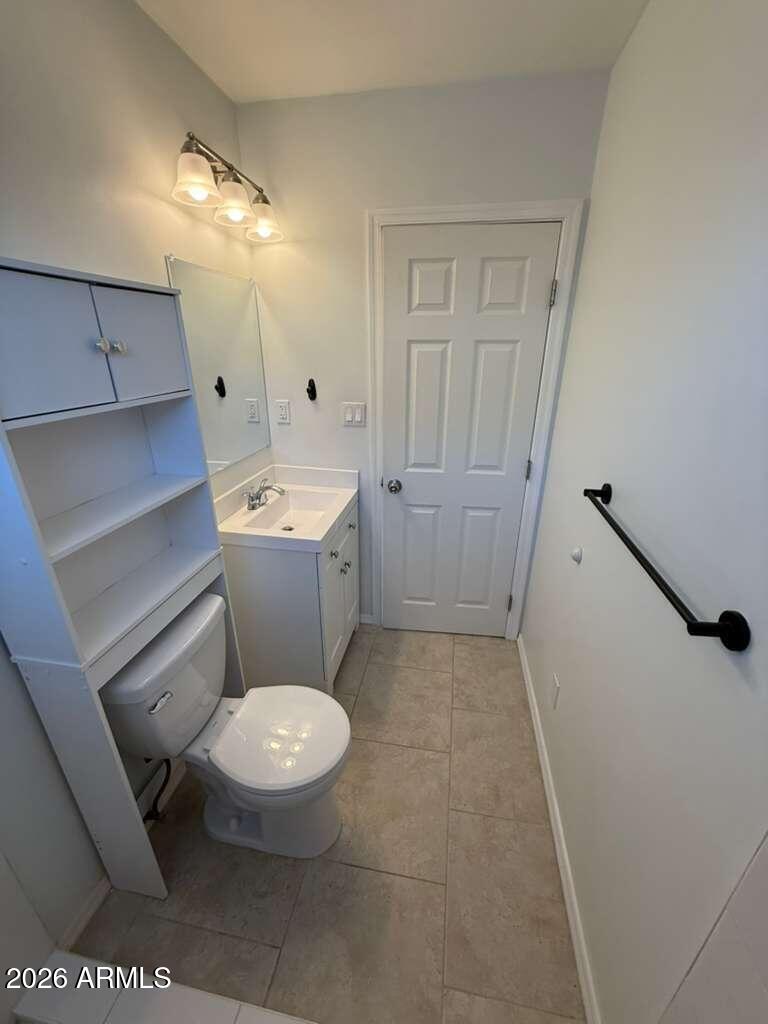 1134 East 23rd Street Douglas, AZ 85607 - Photo 12 of 17 a bathroom with a sink a toilet a mirror and vanity