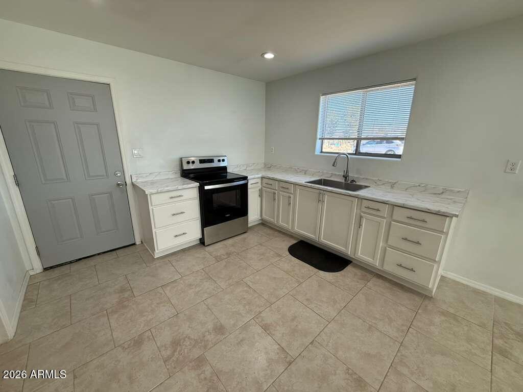 1134 East 23rd Street Douglas, AZ 85607 - Photo 5 of 17 a large white kitchen with white cabinets